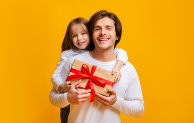 Wall Mural - Little daughter and father holding gift box