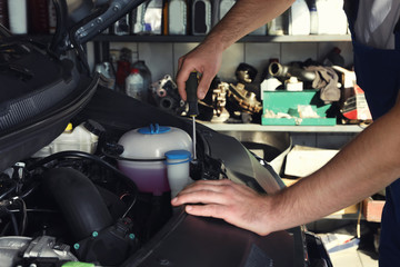 Poster - Professional auto mechanic fixing modern car in service center, closeup