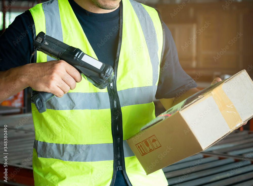 warehouse worker scanning bar code scanner on package box ...