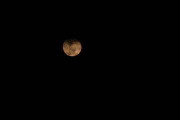 Full white Moon with some clouds passing by in the dark sky