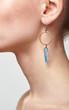 Beautiful woman with galvanic earring in form of blue crystal