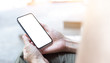 © panitan - soft focus.cell phone Mockup blank white screen.woman hand holding texting using mobile sitting at outdoor.empty space for advertise.work people contact marketing business,technology