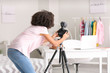 © Pixel-Shot - African-American teenage blogger adjusting camera for recording video at home