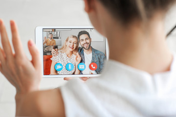 Wall Mural - Young woman video chatting with friends at home