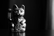 Maneki Neko, the Lucky Cat, covered with dust, black and white. Concept of fast passing time and expectation of good luck