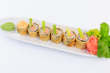 Fototapeta Kuchnia - Sushi, danie kuchni japońskiej, podane na białym talerzu, dodatki warzywa i sałaty.