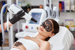 close-up of cosmetologist arm working on female face with beauty laser machine