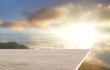 Wall Mural - The wooden table surface is empty for placing items against the rising sunrise background.