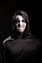 Grim Reaper With A Scary Face Isolated Over Black Background. Evil Face.