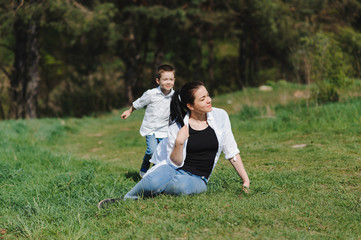 Stilish mother and handsome son having fun on the nature. Happy family concept. Beauty nature scene with family outdoor lifestyle. Happy family resting together. Happiness in family life. Mothers day.