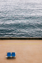 Aerial view at two empty deckchairs on the beach