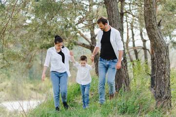 Dad, mom and little son having fun together, outdoors. Family walk in park. Happy family outdoors. Family, vacation concept