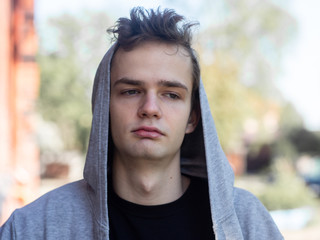 Wall Mural - portrait of handsome sad teenager guy in a hood