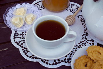 Wall Mural - A cup of tea with pastries, natural light on wooden vintage table