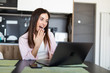 © F8  \ Suport Ukraine - Joyful surprised woman putting hands to face looking at laptop while sitting at table at home