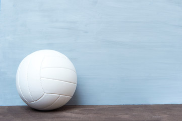 Wall Mural - Close up of volleyball ball on grey floor. Online workout concept