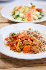 Wall Mural - meat with buckwheat and salad on the wooden background