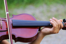 Young Girl Playing Violin Outdoors