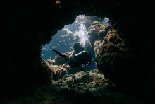 Typical Underwater Cave In A Red Sea Reef With An Underwater Photographer Diver