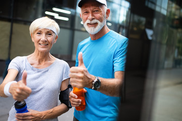 Wall Mural - Healthy senior, couple jogging in the city at early morning with sunrise