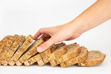 Female hand touching one slice of cereal loaf. Sliced bread made of rye flour isolated on white background. Studio shot. Side view. Homemade bakery and cooking at home concept