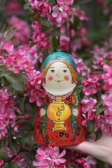 Wall Mural - Matryoshka. Nested doll. Russian traditional handicraft. Wooden nesting toy: vintage matryoshka. Pink flowers of blossoming spring apple-tree, grade 