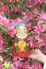 Wall Mural - Matryoshka. Nested doll. Russian traditional handicraft. Wooden nesting toy: vintage matryoshka. Pink flowers of blossoming spring apple-tree, grade 