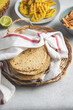 Stack of mexican corn tortillas in a wicker tray covered with kitchen towel