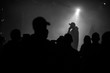A silhouette of singer rap musician during live concert in dark light. Dark background, smoke, spotlights