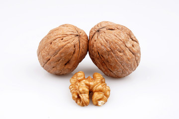 Two walnuts and walnuts with organic shell on a white background