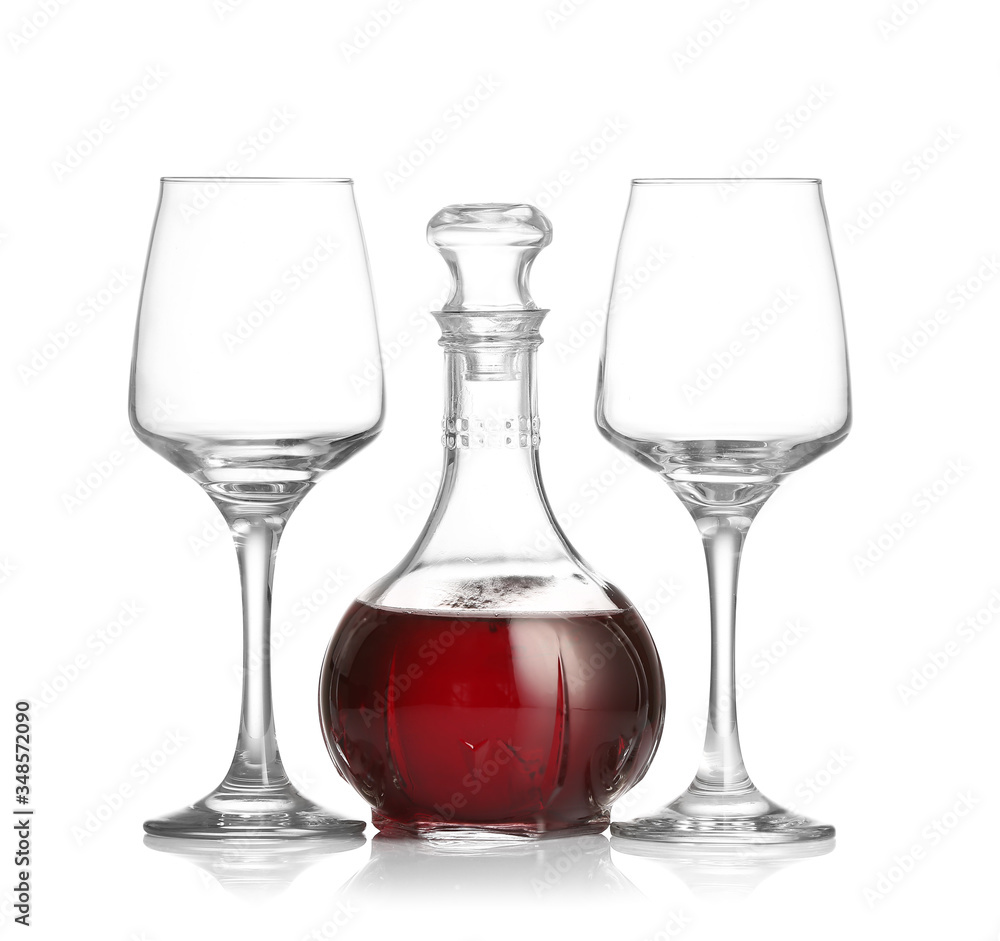 Decanter of wine and glasses on white background