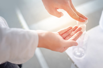 Male hand pumping bottle of alcohol sanitizer or alcohol gel in public area. Coronavirus (COVID-19) outbreak infection prevention and control. Hygiene and health care concept