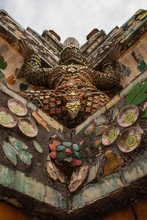 Warrior Covered In Colored Ceramic Pieces Holding The Temple Of Wat Arun In Bangkok