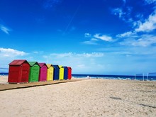 Multi Colored Huts At Beach Against Blue Sky