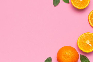 Fruit, creative summer concept. Fresh juicy whole and sliced orange, mint leaves on pink background. Flat lay Top view copy space. Minimalistic background with citrus fruits, vitamin C. Pop art design