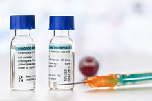 Chloroquine Phosphate (generic Name) Drug In Small Injection Bottles With Blue Caps, Orange Green Syringe Near (own Label Design With Dummy Data - Not Real Product) Potential Coronavirus Cure Concept