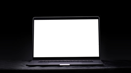 Computer with blank screen on a black background. Mockup and space for text and advertising