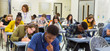 © Chris Ryan/Caia Image - High school teacher supervising students taking exam at desks