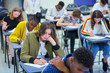 © Chris Ryan/Caia Image - High school girl student taking exam at desk in classroom