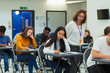 © Paul Bradbury/Caia Image - High school teacher supervising students taking exam at desks