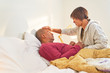 © Trevor Adeline/Caia Image - Affectionate wife checking fever of sick husband in bed