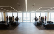 © Martin Barraud/Caia Image - Business people talking in modern highrise office lobby