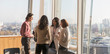 © Tom Merton/Caia Image - Business people talking at sunny urban highrise office window