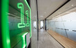 © Chris Ryan/Caia Image - Neon sign in modern business office corridor