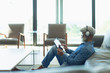 © Paul Bradbury/Caia Image - Man relaxing, listening to music with headphones and digital tablet in living room