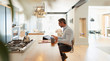 © Paul Bradbury/Caia Image - Businessman at digital tablet working from home in modern kitchen