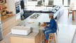 © Paul Bradbury/Caia Image - Man eating breakfast and using smart phone in modern kitchen