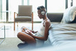 © Paul Bradbury/Caia Image - Young woman listening to music with headphones and digital tablet in living room