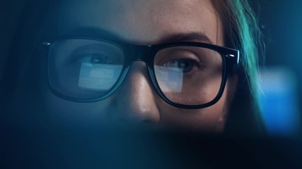 Close up of tired woman using chat got ai and working at night on laptop, girl in eye glasses with reflections overworking busy, using computer in dark office