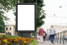 Billboard In The City In Front Of A Flower Bed In The City With People Passing By